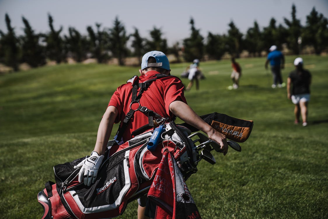 Golfeur marchant sur un parcours de golf verdoyant par une journée ensoleillée